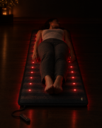 Deep Delta Field Mat in use, person lying full length on the lit mat in a dark room